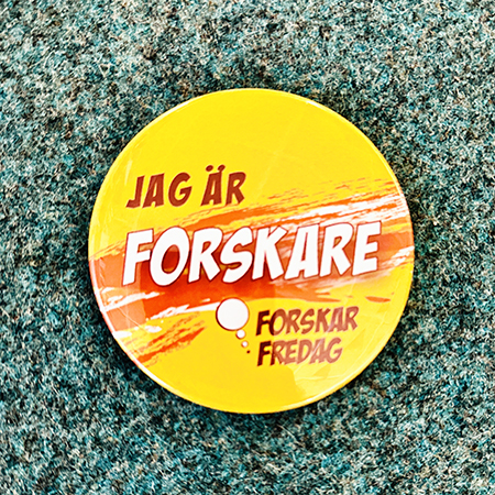 Rund pin med texten "Jag är forskare" mot en neutral bakgrund. Foto.
