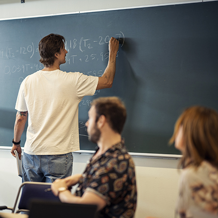 Student skriver formler på svart tavla. Foto av Johan Persson