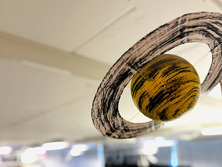 En modell av Planeten Saturnus som hänger i taket på Vattenhallen. Foto.