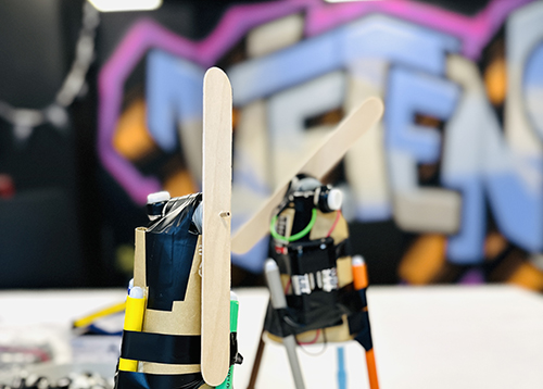 Robot av pennor och pappmugg på bord. Foto. 