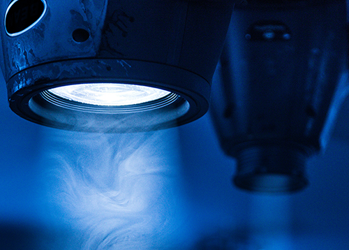 Ett mikroskop med blått ljus i närbild. Foto. 