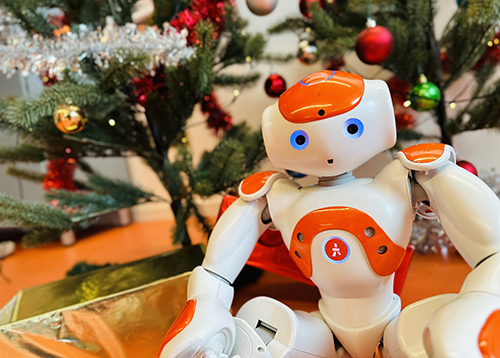 Roboten Nao framför julgran. Foto. 