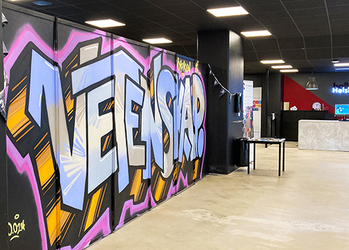 Grafittimålning med texten "Nyfiken på vetenskap" i våra lokaler på Campus Helsingborg. Foto. 
