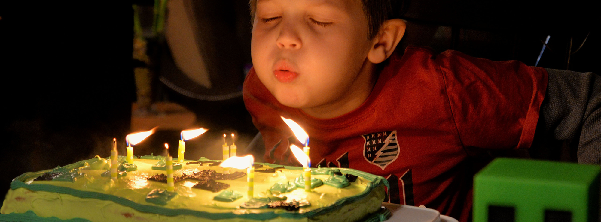 Boy blowing out candles on birthday cake